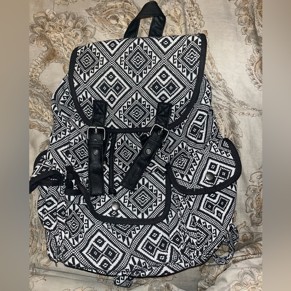 Black and white patterned backpack with buckles.